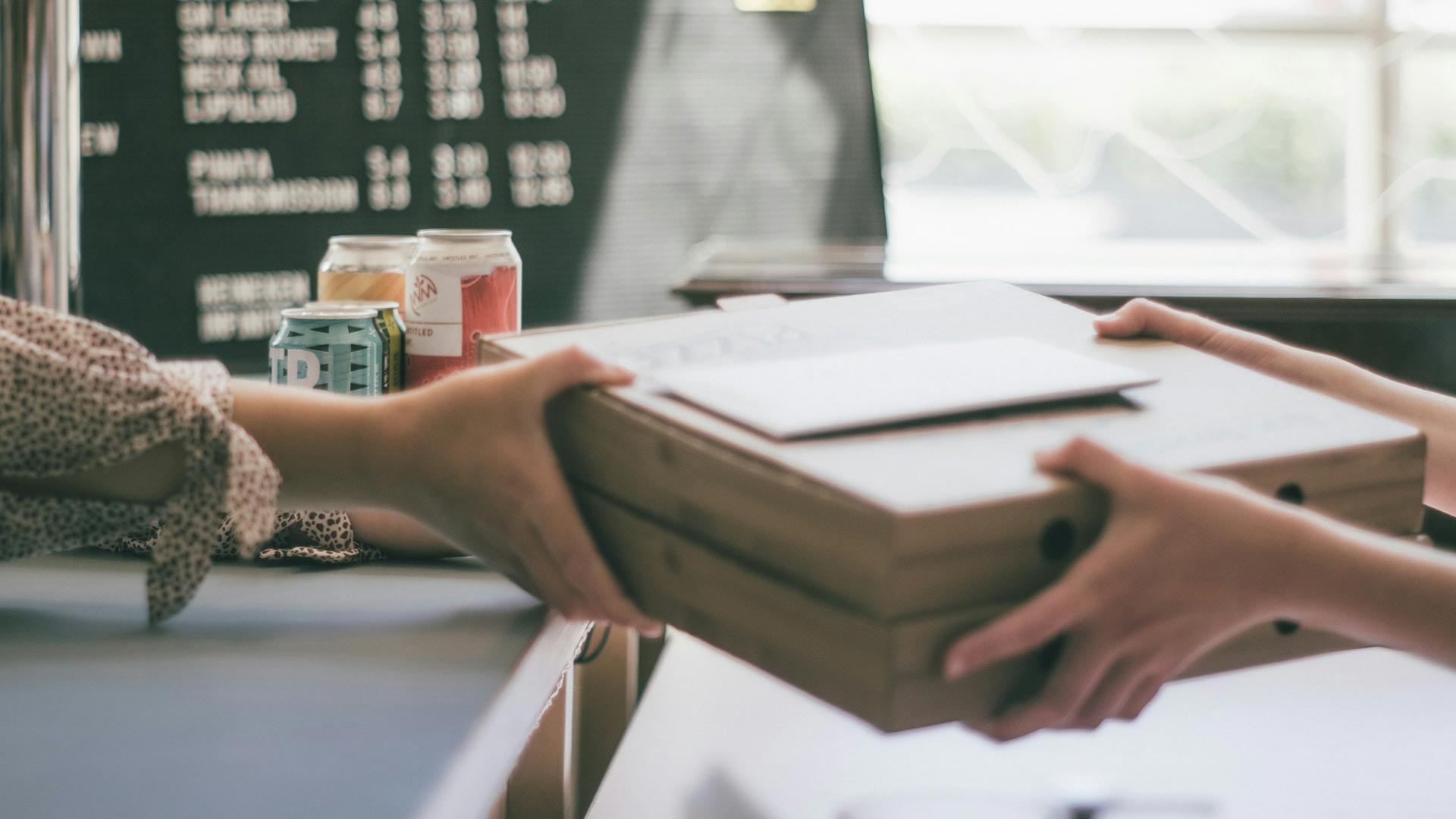 Small business owner handing customer a print package